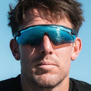 Matte black Phantoms safety glasses with blue lenses, worn on a person's face, full-face view