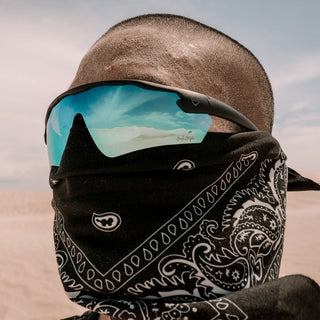Matte black Phantoms safety glasses with blue lenses, worn on a person's face, full-face view