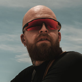 Matte black Phantoms safety glasses with red lenses, worn on a person's face, frontal view